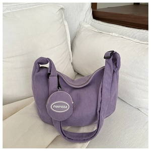 Detail of purple corduroy crescent bag with matching FANYISSA round coin purse pendant