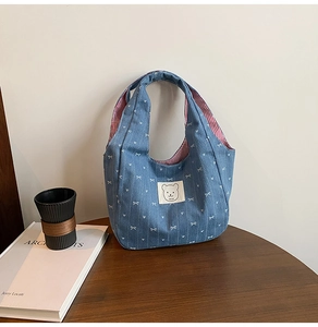 Details der blauen Jeans-Handtasche mit weißen Schleifen und rot gestreiftem Futter