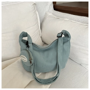 Detail of light blue waffle texture knit shoulder bag with matching round coin purse