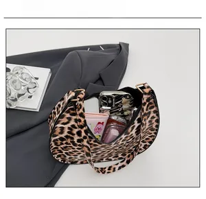 Detailed interior capacity of leopard print shoulder bag showing essentials