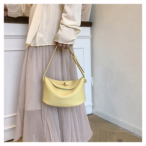 Litchi texture detail of yellow Lindy style shoulder bag with metal turn-lock closure
