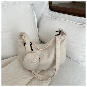 Detail of beige waffle textured nylon half-moon shoulder bag with small round coin pouch