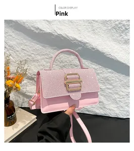 Detailaufnahme einer rosa Pailletten-Handtasche mit goldener Metallschnalle und Gurt