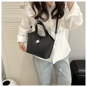 Detail of silver metal buckle on minimalist black tote bag with premium leather texture