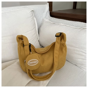 Detail of mustard yellow corduroy crescent bag with matching round coin purse and logo