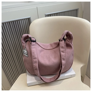 Détail du sac bandoulière rose à texture gaufrée avec un pendentif chiot mignon