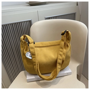 Détail du sac cabas en velours côtelé jaune avec texture douce et breloque chien