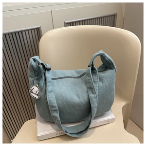 Détail du grand sac cabas en velours côtelé bleu clair avec bandoulière et porte-clés