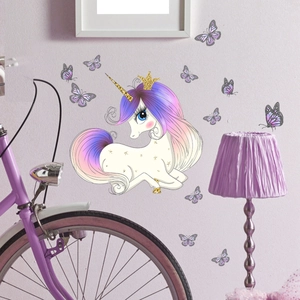Detailed view of luminous unicorn and butterfly wall stickers on a soft pastel wall