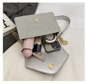 Silver glitter crossbody bag interior showing phone, makeup, and umbrella capacity