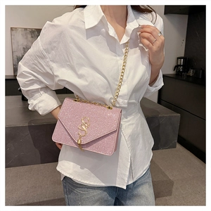Détail d'un sac à bandoulière rose à paillettes avec boucle dorée et bandoulière