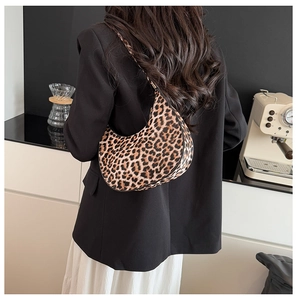 Detailed view of fashionable leopard print hobo bag worn with a black blazer