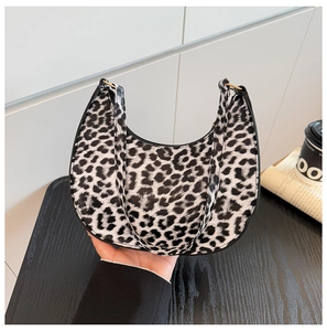 Detail of leopard print hobo bag with gold hardware and black leather trimming