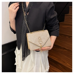 Mannequin portant un sac doré pailleté avec franges et bandoulière chaîne