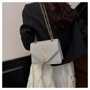 Silver glitter chain bag with gold SS logo shown on a model from a side perspective