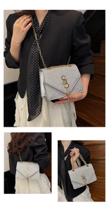 Détail du sac enveloppe pailleté argenté avec logo S doré à franges et bandoulière chaîne