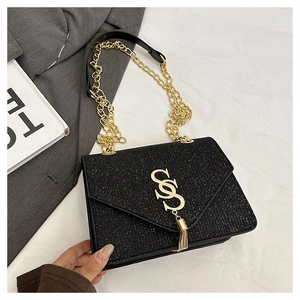 Détail du sac bandoulière noir scintillant avec logo SOS doré et franges
