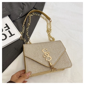 Détail du sac bandoulière pailleté champagne doré avec pompon et chaîne en or