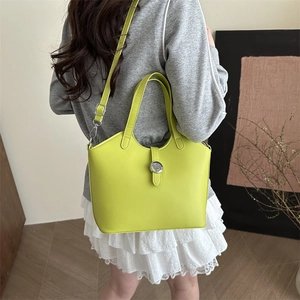 Chic bright green leather bucket bag with top handles and adjustable shoulder strap for women