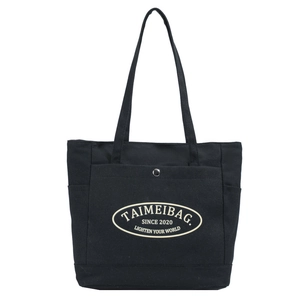 Black canvas tote bag with large capacity featuring oval logo print and metal snap front pocket