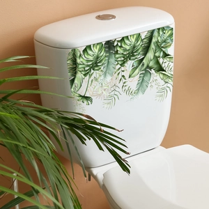 Tropical green leaves toilet sticker with gold details on white ceramic surface