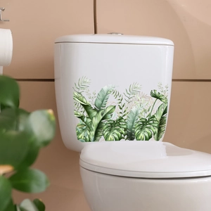 Detail of tropical plant stickers with banana leaves and monstera on a white toilet tank