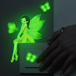 Luminous wall sticker showing a fairy and butterflies glowing green near a light switch