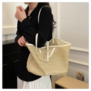 Detail of summer woven straw tote with white faux leather straps and fine mesh texture