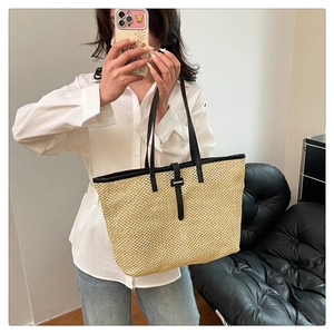 Large straw tote bag with black leather straps shown in a lifestyle mirror selfie