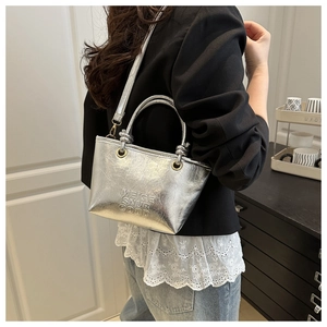 Close-up of metallic silver bucket bag with wrinkled texture and embossed letters