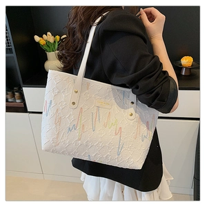 Vue détaillée du grand sac cabas blanc avec broderie rayée et cuir texturé de haute qualité
