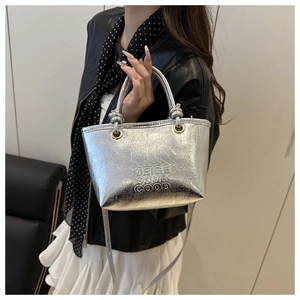 Close-up of silver metallic bucket bag with pearl pleat texture and round handle