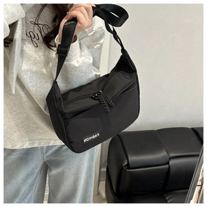 Detail of black oxford nylon crossbody bag featuring double zippers and a FASHION label