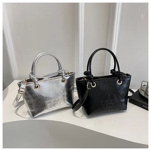 Detail view of silver and black mini tote bags with embossed texture and metal hardware