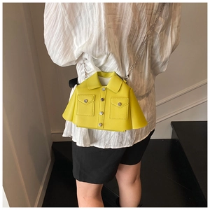 Detail of creative bright yellow jacket-shaped crossbody bag with silver chain strap