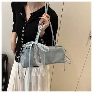 Détail du sac à bandoulière en cuir verni bleu clair avec nœud en dentelle et rubans de soie