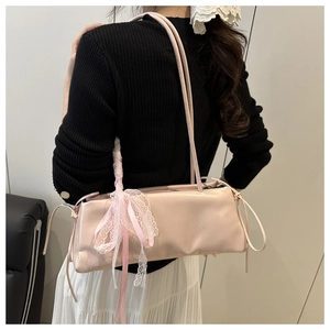 Dettaglio della borsa baguette rosa in pelle cerata con fiocco in pizzo e lacci