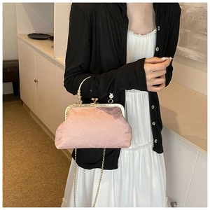 Detail of pink embroidered qipao bag with textured floral jacquard and gold metal handle