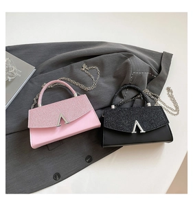 Détail de mini sacs à main rose et noir avec rabat scintillant et boucle en métal en V