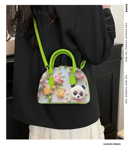 Detail of 3D knit panda and floral motifs on green shell-shaped crossbody handbag
