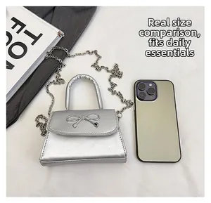 Macro shot showing silver mini bag size comparison with a phone and internal capacity