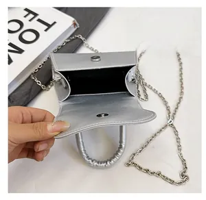 Macro view of silver mini crossbody bag interior with chain strap and magnetic snap