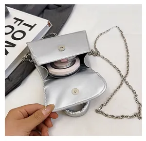 Detailed interior of a silver chain crossbody bag showing capacity and magnetic closure