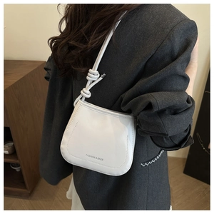 Detail view of cream leather underarm bag with knot strap and Fashion & Bags text