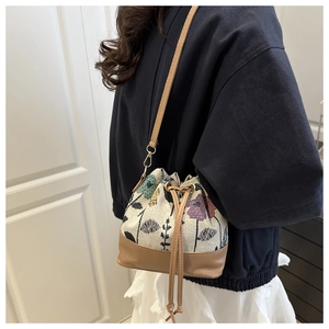 Details der Kordelzug-Beuteltasche mit Blumenmuster und braunem Lederbesatz