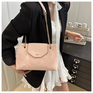 Detailed macro view of pink snake-pattern embossed leather bag with gold chain strap
