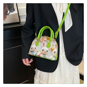 Detail of floral shell bag with 3D crochet rabbits and vibrant green handles