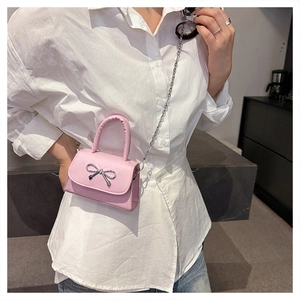 Detailed shot of pink mini crossbody bag with silver bow buckle and chain strap