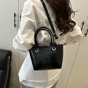 Fashionable black glossy bucket bag with letter embossing and adjustable strap