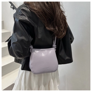 Dettaglio della borsa in vernice lilla con scritta Fashion & Bags sulla spalla